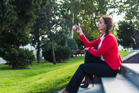 businesswoman in a red suit rests on the steps.