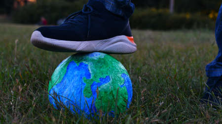 ball in the shape of a globe. the foot is on the ballの写真素材