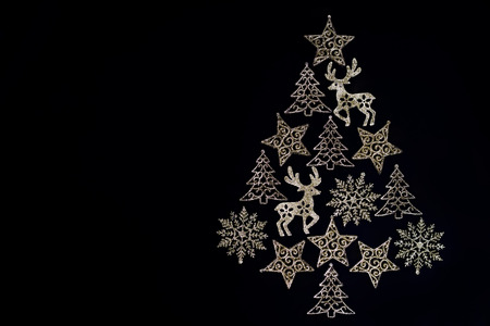 Christmas tree made of golden, sparkly Christmas ornament on black background. Holiday season, flat...