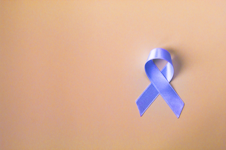 Blue ribbon prostate cancer symbol on pastel background. Cancer awareness month and healthcare concept.  Copy space.の写真素材