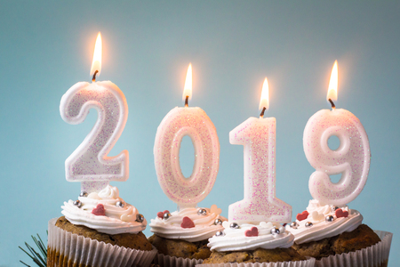 Happy New Year 2019 cupcakes with lighting candles. Merry Christmas and winter season greetings concept. Close up.の写真素材