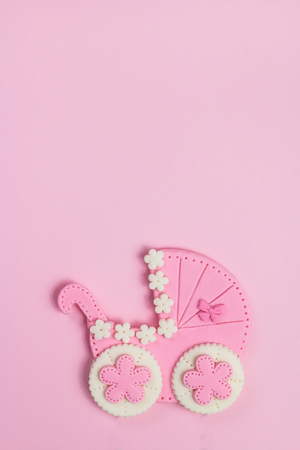 Sweet  baby stroller made of fondant on a pink background. Welcome baby girl concept, minimal style. Baby shower invitation. Baby announcement. Flat lay,text space.の写真素材