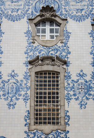 Window of Carmo and Carmelitas church in Porto. Detail of traditional historic facade in Porto decorated with blue hand painted tin-glazed tiles, Oporto, Portugal.の写真素材