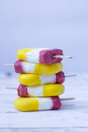 Ice cream pops made with mango, raspberry  and yogurt. Summer refreshment. Homemade healthy dessert. Recipe ideas. Close upの写真素材