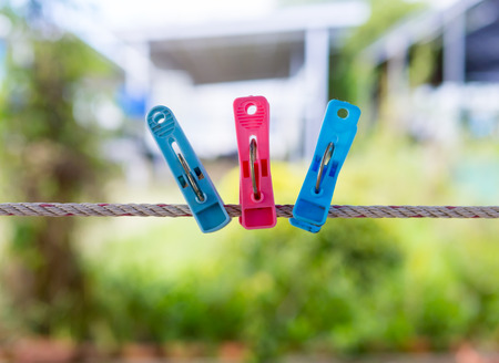 Multicolored beautiful clothespins hanging on a cord, blur background