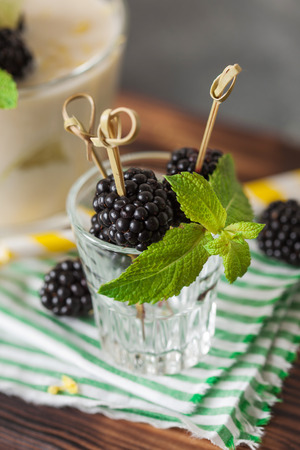 Lemon milkshake garnished with blackberry and mint close upの写真素材