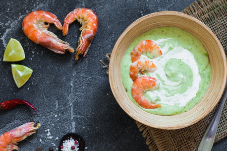 Savory gourmet soup with shrimps served in bowl on black slate background, copy spaceの写真素材