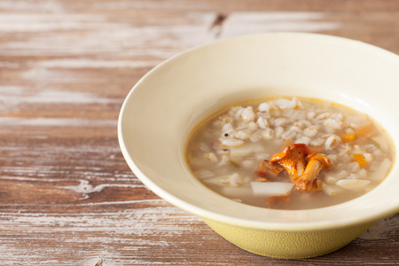 Chanterelle cream soup on wooden background, selective focus copy spaceの写真素材