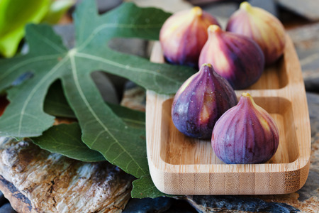 Fresh figs in wooden bowl, ripe and healthy sweet mediterranean fig fruit close upの写真素材