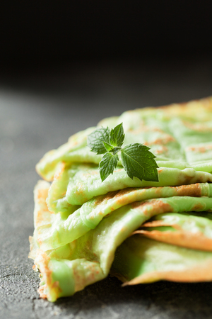 Japaneese matcha crepes with mint on black slate background copy spaceの写真素材