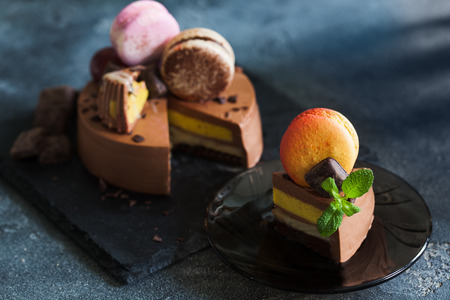 Chocolate cheesecake with banana filling decorated with macarons and toffee. Healthy organic summer dessert pieの写真素材