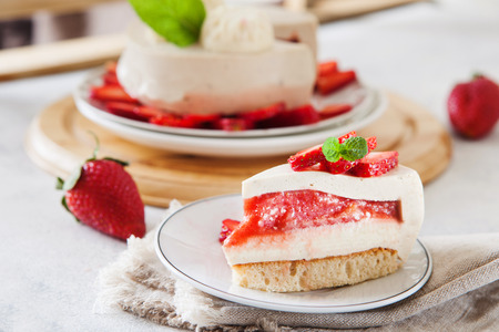 Slice of cheesecake with strawberry filling decorated with fresh berries and mint. Healthy organic summer dessert pie.の写真素材