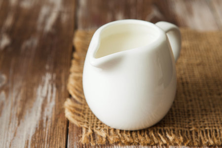 Fresh milk in jug on the wooden table for breakfast copy spaceの写真素材