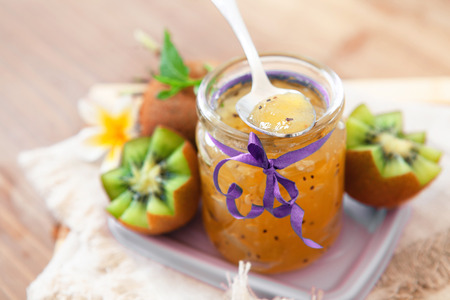 Exotic homemade kiwi jam with ripe fruits on wooden background, copy spaceの写真素材