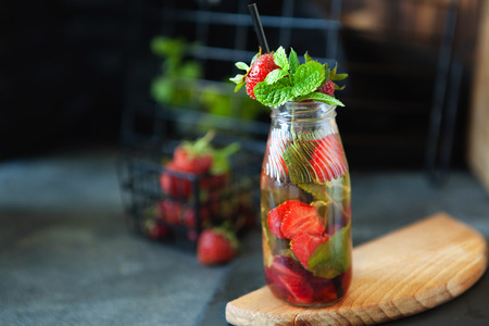 Strawberry lemonade drink, refreshing summer lemonade with fresh berries and mint on dark background, copy spaceの写真素材