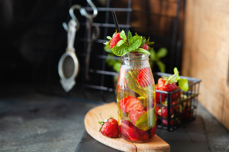 Strawberry lemonade drink, refreshing summer lemonade with fresh berries and mint on dark background, copy spaceの写真素材