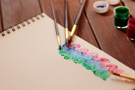 Brushes and glittered paints, abstract artist background on wooden backgroundの写真素材