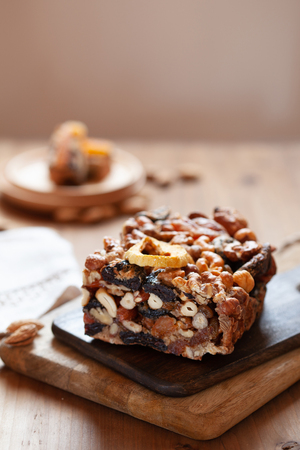 Healthy fruit cake with dried fruits and mix nuts trafitional for Jewish holiday Tu Bishvat on wooden boardの写真素材