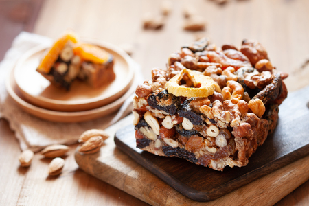 Healthy fruit cake with dried fruits and mix nuts trafitional for Jewish holiday Tu Bishvat on wooden boardの写真素材