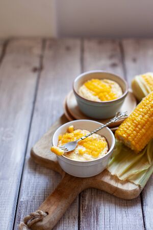 Chicken breast souffle with corn in ramekin on old wooden tableの写真素材