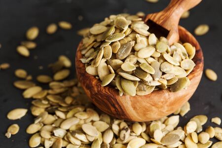 Raw pumpkin seeds on black slate background copy spaceの写真素材