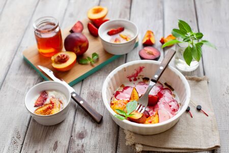 Greek yogurt with grilled fruits and honey. Easy healthy sweet summer dessert with plum and peachの写真素材