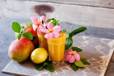 Fresh tropical fruit smoothie mango juice with leaves and fruits の写真素材
