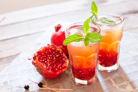Mojito cocktail with pomegranate, mint, lemon juice and ice copy spaceの写真素材
