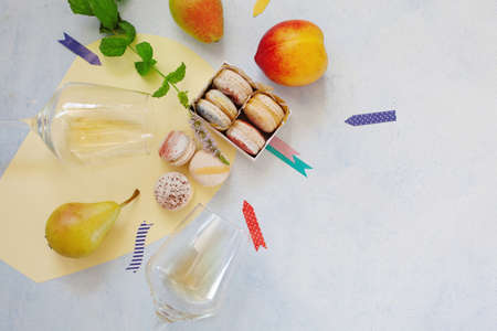 Top view of box with macarons and wine glasses copy space, party conceptの写真素材