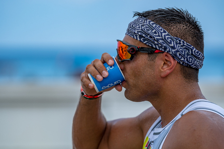 Young man drinking water during ironmanのeditorial素材