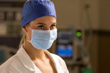 Young female doctor in surgical mask in ICUの写真素材