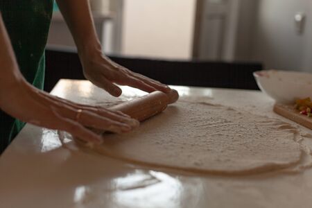 Preparation of the dough for pizza. Hands prepare the dough