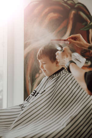 The work of the barbershop. Haircut of a boy in a barbershop. Children's haircutの写真素材
