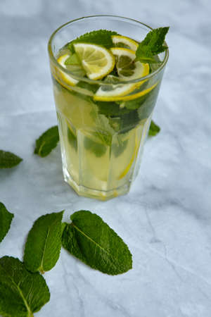 Refreshing drinks for summer, cold sweet and sour lemonade juice in the glasses with sliced fresh lemons. Refreshing summer drink. Traditional lemonade with lemon and mint. Selective focusの写真素材