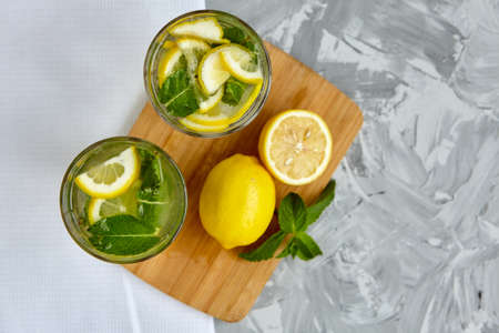 Refreshing drinks for summer, cold sweet and sour lemonade juice in the glasses with sliced fresh lemons. Refreshing summer drink. Traditional lemonade with lemon and mint. Selective focusの写真素材
