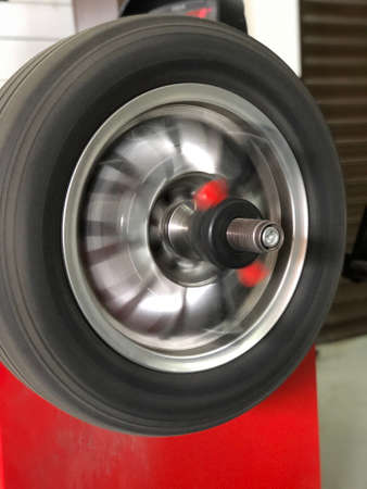 Wheel balancing or repair and change car tire at auto service garage or workshop by mechanicの写真素材