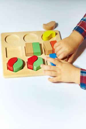 The child collects a sorter. Educational logic toys for kid's. Children's hands close-up. Montessori...