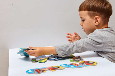 Child playing with puzzles ,. The boy is playing in his room. Educational logic toys for kid's.の写真素材