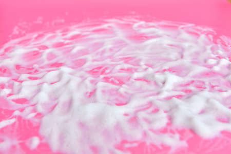 Washing concept. Soap foam on delicate pink background with copy spaceの写真素材