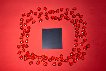 a blank piece of paper for a note. Valentines day hearts background. Many colorful hearts -...