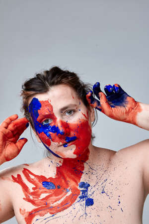 Portrait of a woman with a painted face. Creative makeup and bright style.Girl with colored face...