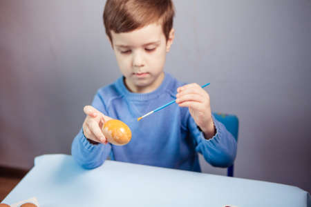 Little Boy painting Easter Eggs with Paint at Home. Children's Easter creativity. A child decorate Easter eggs.の写真素材