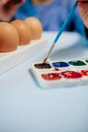 Little Boy painting Easter Eggs with Paint at Home. Children's Easter creativity. A child decorate Easter eggs.の写真素材