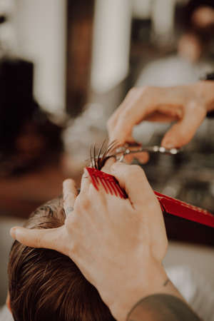 The work of the barbershop. Haircut of a boy in a barbershop. Childrens haircutの写真素材