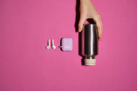 Reusable iron water bottle in a womans hand. Steel water bottle to limit the use of plastic bottlesの写真素材