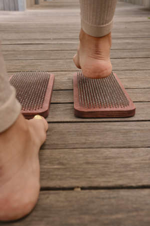 The practice of self-knowledge in the park. A woman with a pedicure stands on sharp nails. Female...