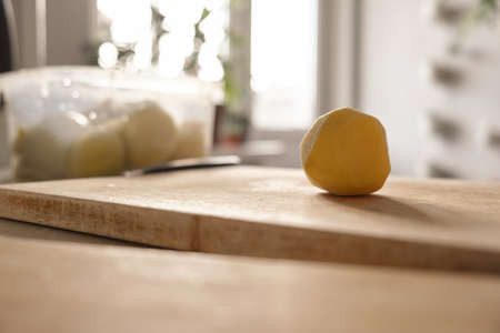 Cooking. Close-up of a kitchen knife in female hands. A woman cuts vegetables for soup. A knife cuts potatoes on a wooden boardの写真素材