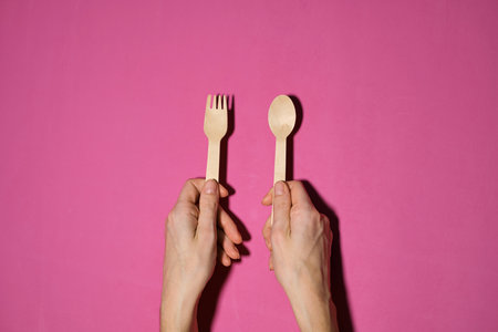 Wooden spoon, fork, paper cups gray background. Disposable tableware made of natural materials. The concept of a zero waste, sustainable lifestyle. Eco-friendly disposable tablewareの写真素材