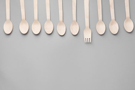Wooden spoon, fork, paper cups gray background. Disposable tableware made of natural materials. The concept of a zero waste, sustainable lifestyle. Eco-friendly disposable tablewareの写真素材