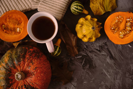 Cup hot tea on the gray table with pumpkin, leaves, spices on the background. Autumn concept. Top view. High quality footageの写真素材
